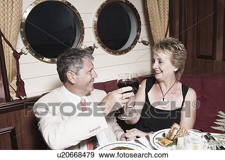 Stock Photo - Senior man and a mature woman toasting with wine glasses. Fotosearch