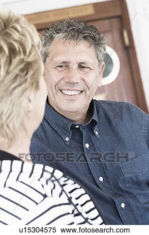 Stock Photography - Senior man talking to a mature woman and smiling. Fotosearch