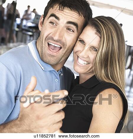 Stock Image - Side profile of a mid adult couple dancing in a nightclub and smiling. Fotosearch