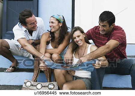 Stock Photography - Two mid adult couples sitting on steps and smiling. Fotosearch