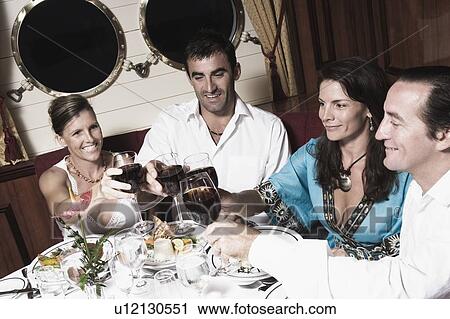 Two mid adult couples toasting with wine glasses and smiling View Large Photo Image Stock Image - Two mid adult couples toasting with wine glasses and smiling. Fotosearch