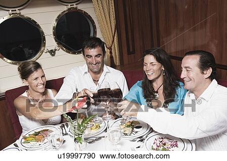 Two mid adult couples toasting with wine glasses and smiling View Large Photo Image Stock Image - Two mid adult couples toasting with wine glasses and smiling. Fotosearch