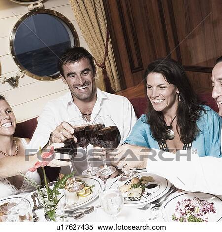 Two mid adult couples toasting with wine glasses and smiling View Large Photo Image Stock Photography - Two mid adult couples toasting with wine glasses and smiling. Fotosearch