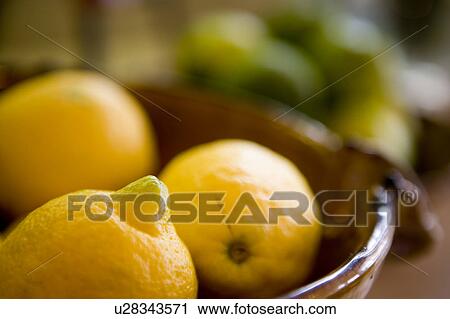 Stock Image - Detail of bowls with lemons and soft focused limes. Fotosearch