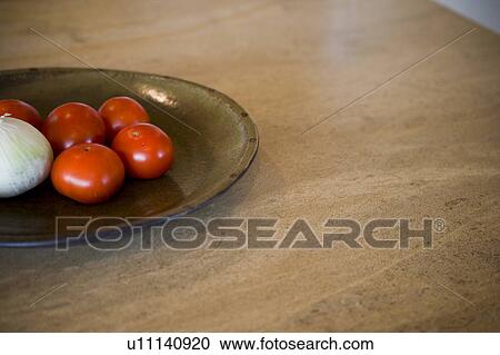 Stock Image - Detail of tomatoes and onion on plate. Fotosearch