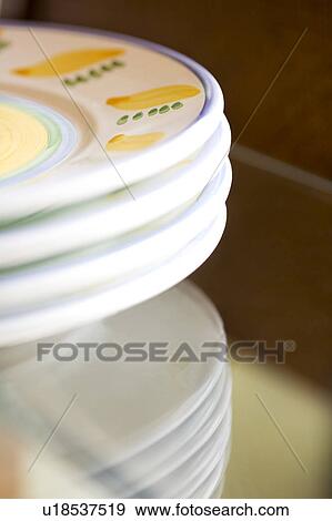 Four plates stacked on a glass table View Large Photo Image Stock Photo - Four plates stacked on a glass table. Fotosearch