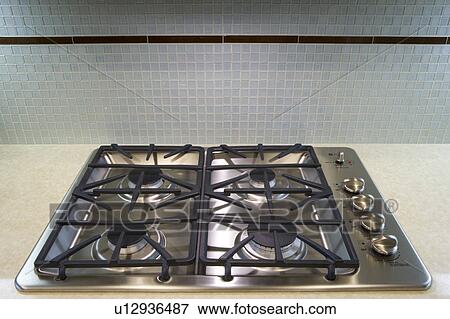 Stock Photo - Gas stove range with glass tile back splash. Fotosearch