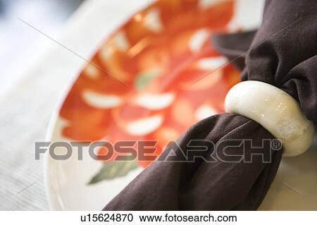 Stock Image - Place setting with plate, napkin, and napkin ring. Fotosearch