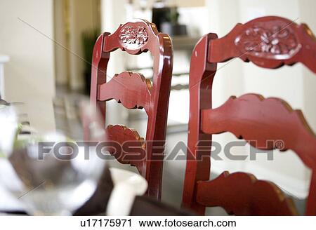 Stock Image - Two red chairs at dining table. Fotosearch