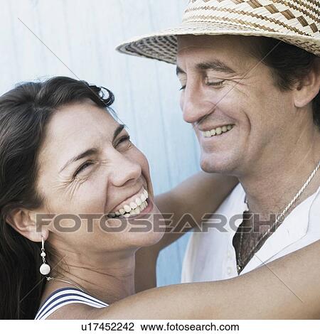 Close-up of a mid adult couple embracing each other and smiling View Large Photo Image Stock Image - Close-up of a mid adult couple embracing each other and smiling. Fotosearch