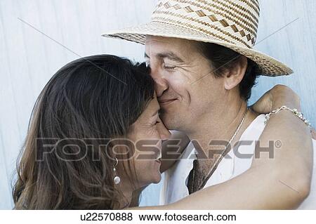 Close-up of a mid adult couple embracing each other and smiling View Large Photo Image Stock Photo - Close-up of a mid adult couple embracing each other and smiling. Fotosearch