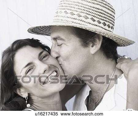 Close-up of a mid adult man kissing a mid adult woman View Large Photo Image Stock Photography - Close-up of a mid adult man kissing a mid adult woman. Fotosearch