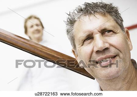 Stock Image - Close-up of a senior man with a mature woman standing behind him. Fotosearch