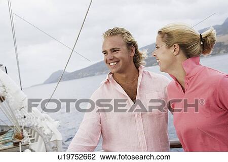 Close-up of a young couple smiling View Large Photo Image Stock Image - Close-up of a young couple smiling. Fotosearch