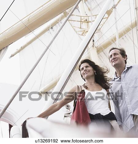 Low angle view of a mid adult couple standing with their arms outstretched View Large Photo Image Stock Image - Low angle view of a mid adult couple standing with their arms outstretched. Fotosearch