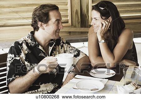 Mid adult couple looking at each other and smiling in a restaurant View Large Photo Image Stock Photo - Mid adult couple looking at each other and smiling in a restaurant. Fotosearch