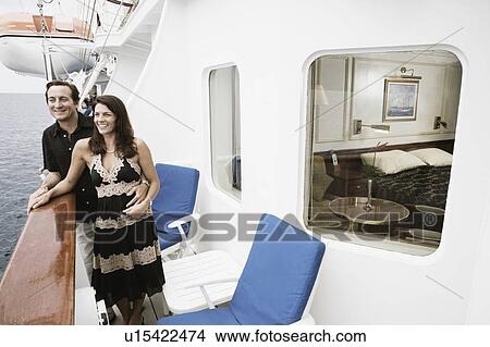Mid adult couple standing at the railing of a sailing ship and smiling View Large Photo Image Picture - Mid adult couple standing at the railing of a sailing ship and smiling. Fotosearch