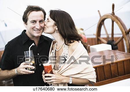 Mid adult woman kissing a mid adult man on a sailing ship View Large Photo Image Stock Image - Mid adult woman kissing a mid adult man on a sailing ship. Fotosearch