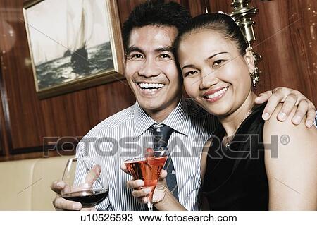 Portrait of a young man sitting with his arm around a young woman and smiling View Large Photo Image Stock Image - Portrait of a young man sitting with his arm around a young woman and smiling. Fotosearch