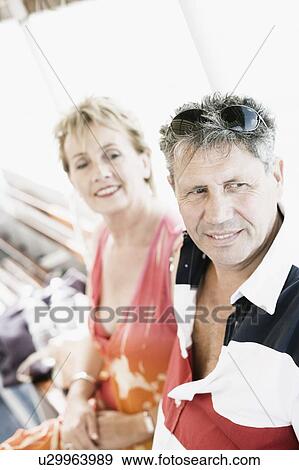 Senior man sitting with a mature woman and smiling View Large Photo Image Stock Photo - Senior man sitting with a mature woman and smiling. Fotosearch