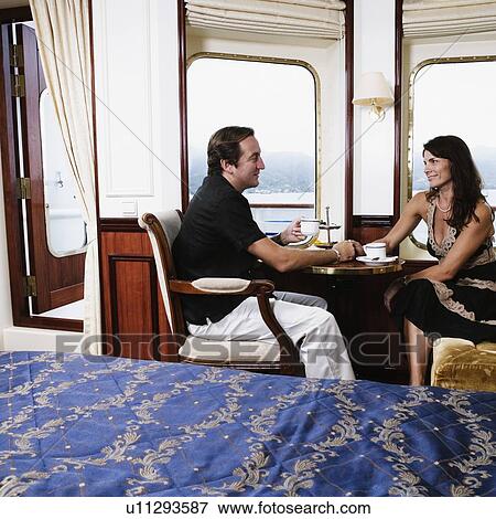 Side profile of a mid adult couple drinking tea in a cabin of a sailing ship View Large Photo Image Stock Photo - Side profile of a mid adult couple drinking tea in a cabin of a sailing ship. Fotosearch