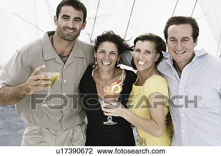 Stock Image - Two mid adult couples smiling together. Fotosearch