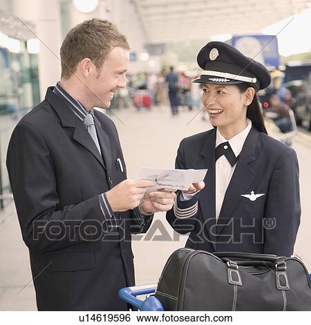 Businessman and a female pilot looking at each other and smiling View Large Photo Image Stock Photograph - Businessman and a female pilot looking at each other and smiling. Fotosearch