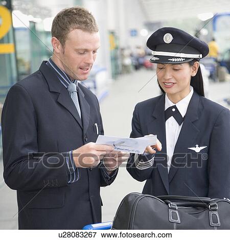 Businessman showing an airplane ticket to a female pilot View Large Photo Image Stock Photo - Businessman showing an airplane ticket to a female pilot. Fotosearch