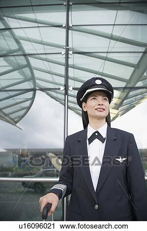 Close-up of a female pilot standing at an airport View Large Photo Image Stock Image - Close-up of a female pilot standing at an airport. Fotosearch