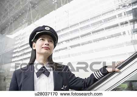 Close-up of a female pilot standing on an escalator View Large Photo Image Stock Image - Close-up of a female pilot standing on an escalator. Fotosearch