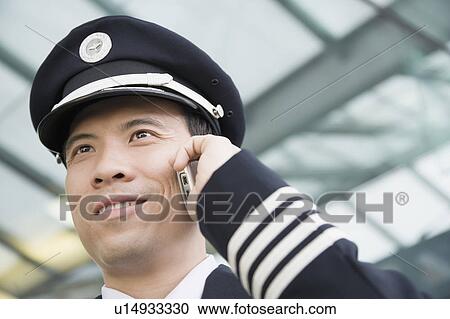 Stock Image - Close-up of a pilot talking on a mobile phone. Fotosearch