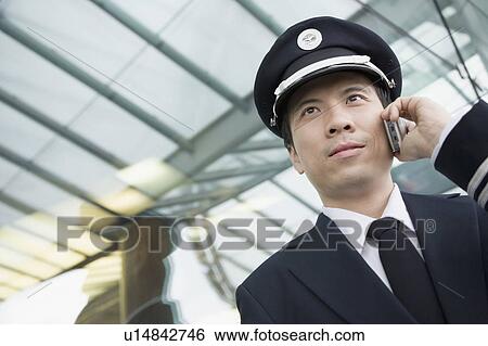 Close-up of a pilot talking on a mobile phone View Large Photo Image Stock Photograph - Close-up of a pilot talking on a mobile phone. Fotosearch