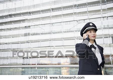 Stock Photograph - Female pilot talking on a mobile phone. Fotosearch