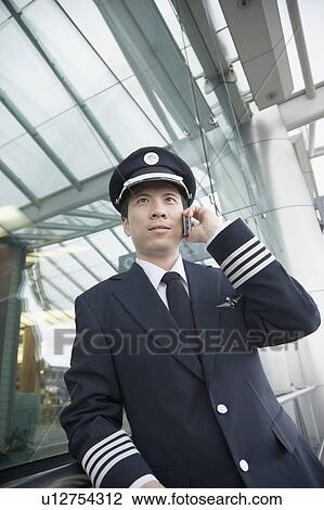 Low angle view of a pilot talking on a mobile phone View Large Photo Image Stock Image - Low angle view of a pilot talking on a mobile phone. Fotosearch