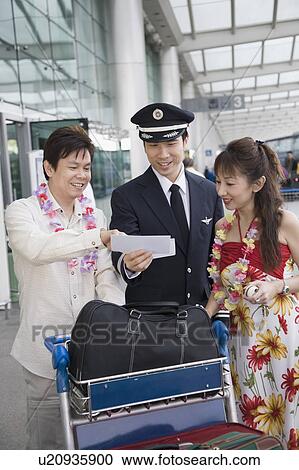 Mature couple showing their airplane tickets to a pilot View Large Photo Image Stock Image - Mature couple showing their airplane tickets to a pilot. Fotosearch