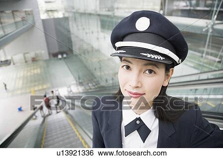 Portrait of a female pilot standing on an escalator View Large Photo Image Stock Photograph - Portrait of a female pilot standing on an escalator. Fotosearch
