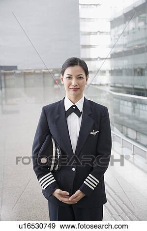 Stock Photo - Portrait of a female pilot standing. Fotosearch