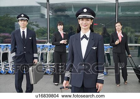 Picture - Portrait of a female pilot with a pilot and two cabin crews standing in the background. Fotosearch