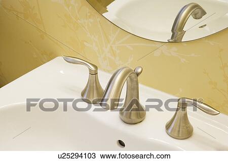 Stock Image - Detail of bathroom faucet, close up. Fotosearch