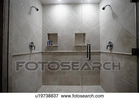 Stock Photo - Detail of dual stone showers with glass door. Fotosearch