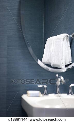 Interior of powder room vanity with sink, mirror and hanging towel View Large Photo Image Picture - Interior of powder room vanity with sink, mirror and hanging towel. Fotosearch