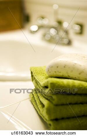 Stock Image - Stack of Green Towels with Soap on Bathroom Counter. Fotosearch