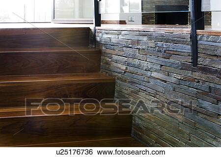 Stock Photograph - Modern hardwood stairway with stone wall. Fotosearch