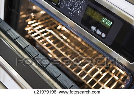 Stock Photograph - Open Oven with Digital Clock. Fotosearch