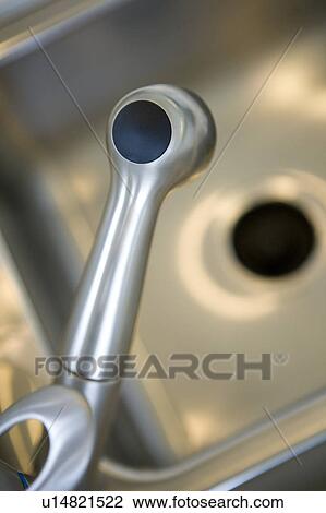 Stock Image - Stainless steel kitchen faucet, close up, high angle. Fotosearch