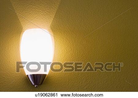 Stock Image - Wall sconce on yellow wall. Fotosearch