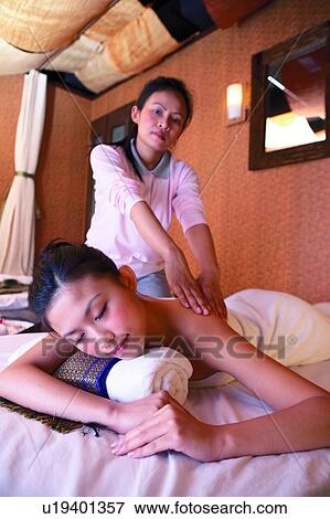Mature woman massaging young woman's shoulder in therapy room View Large Photo Image Stock Photo - Mature woman massaging young woman's shoulder in therapy room. Fotosearch