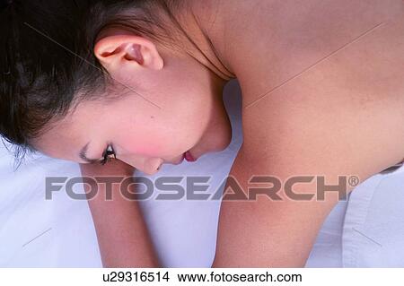 Picture - Young woman lying down, close-up. Fotosearch