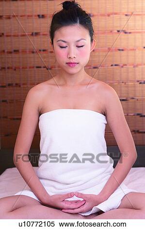 Young woman sitting on massage bed, eyes closed, front view View Large Photo Image Stock Photography - Young woman sitting on massage bed, eyes closed, front view. Fotosearch