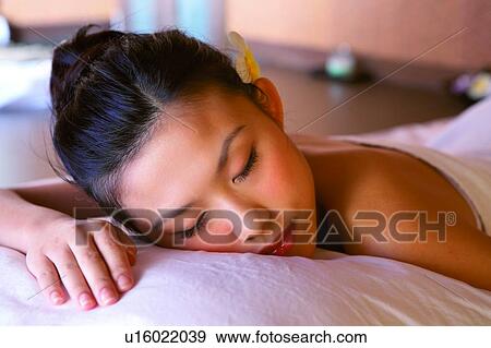 Stock Photo - Young woman wearing towel, lying. Fotosearch